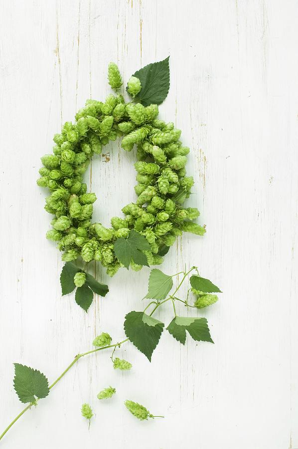 Wreath Of Hops On Wooden Surface Photograph by Achim Sass
