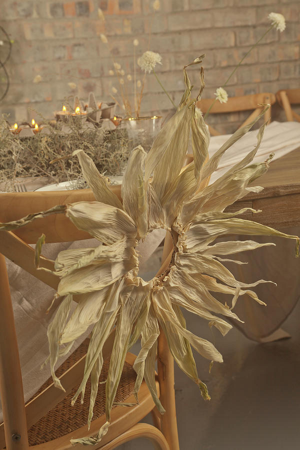 Wreath Of Maize Leaves On Chair At Rustically Set Table Photograph by Great Stock!