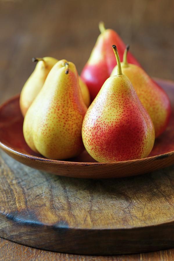 Yellow And Red Pears On A Wooden Plate Photograph by Alena Hrbkov