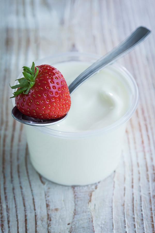 Yoghurt In A Pot With A Strawberry On A Spoon Photograph by Eising Studio