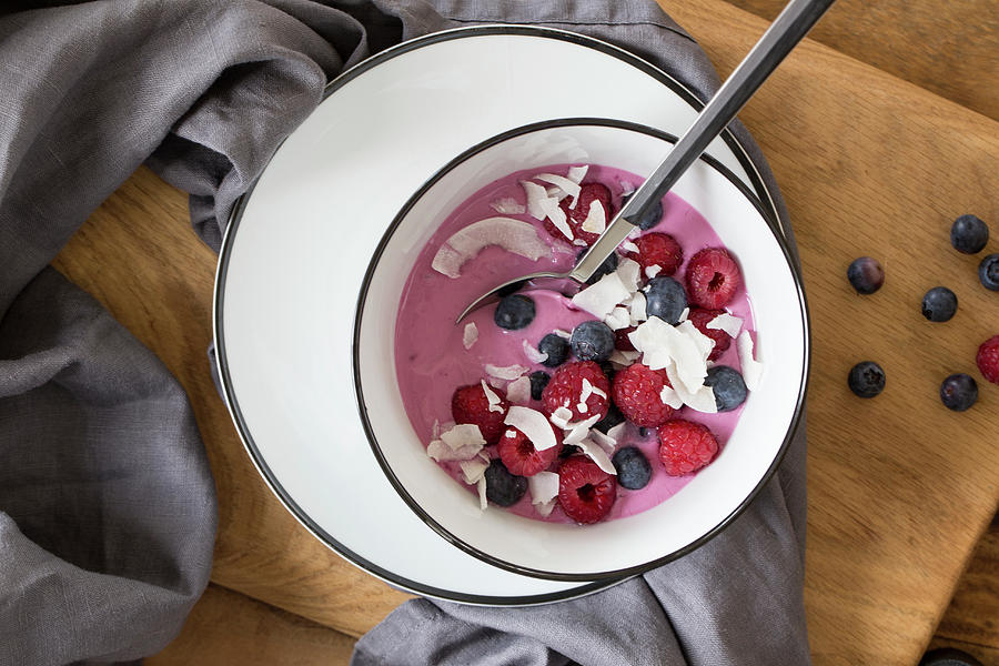 Yoghurt With Acai Podwer Topped With Raspberries, Blueberries And Coconut Chips Photograph by Nicole Godt