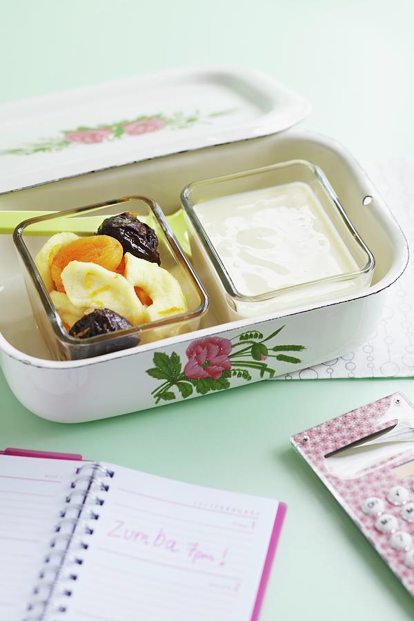 Yoghurt With Dried Apricots, Bananas And Plums In A Lunch Box Photograph by Charlotte Tolhurst