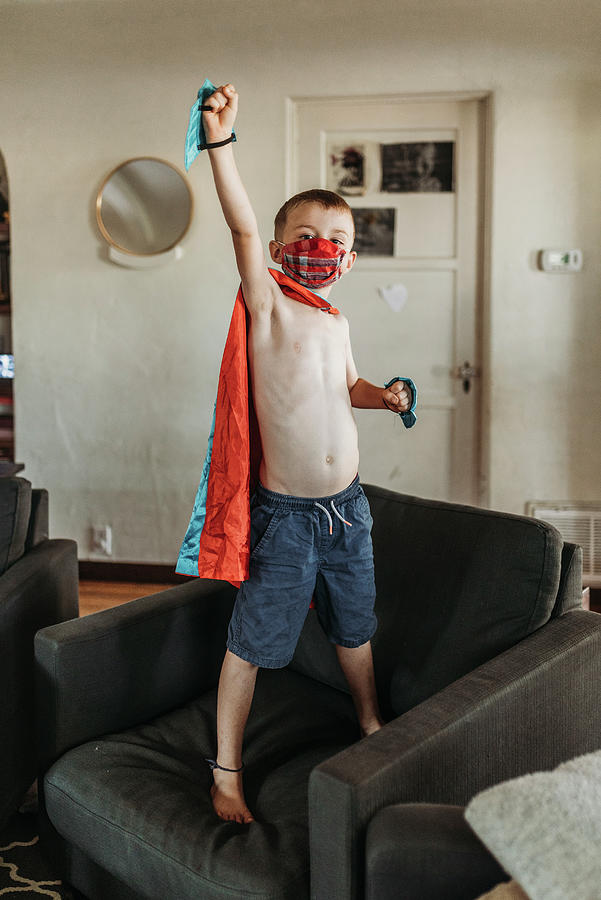 Halloween Photograph - Young Boy Dressed As Super Hero Standing On Couch With Mask On by Cavan Images