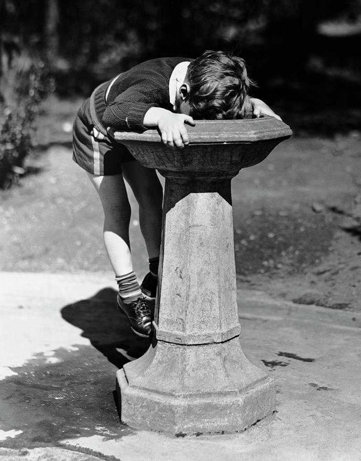Young Boy Drinking From Water Fountain Photograph by George Marks