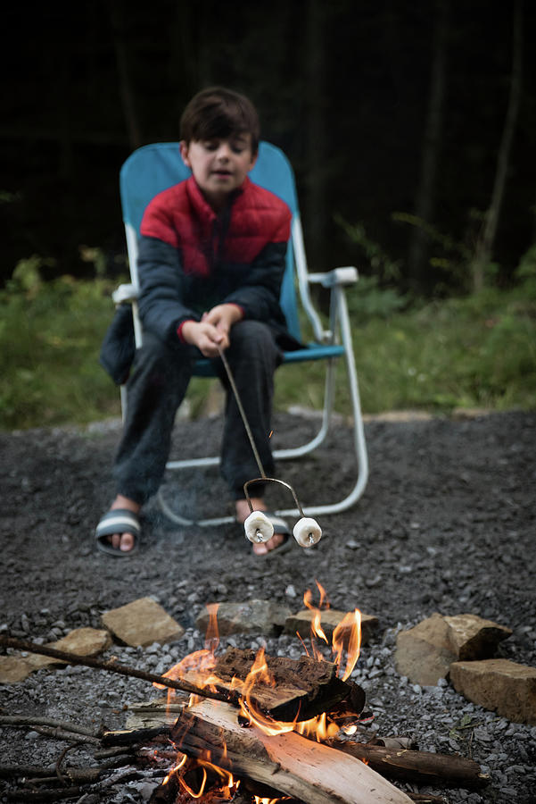 Nature Photograph - Young Boy Roasting Marshmallows On A Metal Stick Over A Fire. by Cavan Images