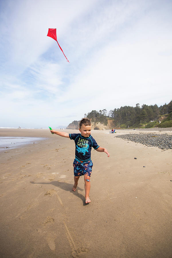 Dragon Photograph - Young Boy Running With Kite On Oregon Coast Beach. by Cavan Images