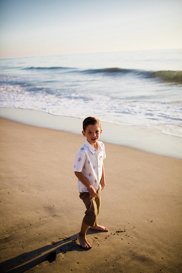 Young Boy Standing On Beach At Sunset Photograph by Cavan Images | Fine ...