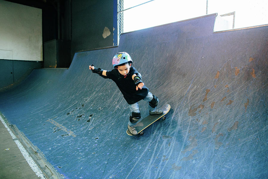 Young Boy Turns His Body As He Skates Up Ramp Photograph by Cavan ...