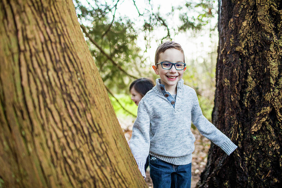 Tree Photograph - Young Boy Wearing Glasses Playing In The Forest. by Cavan Images