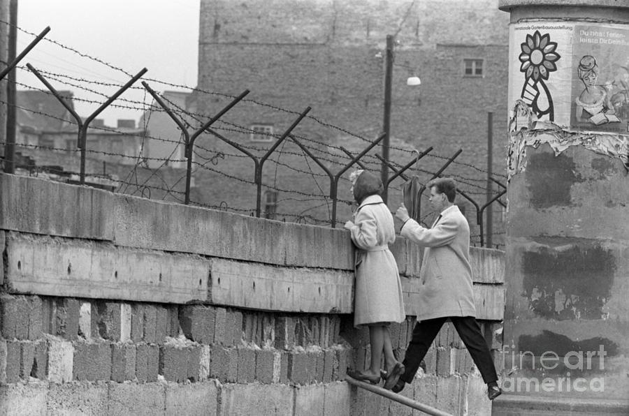 Young Couple Peers Over Berlin Wall Photograph by Bettmann