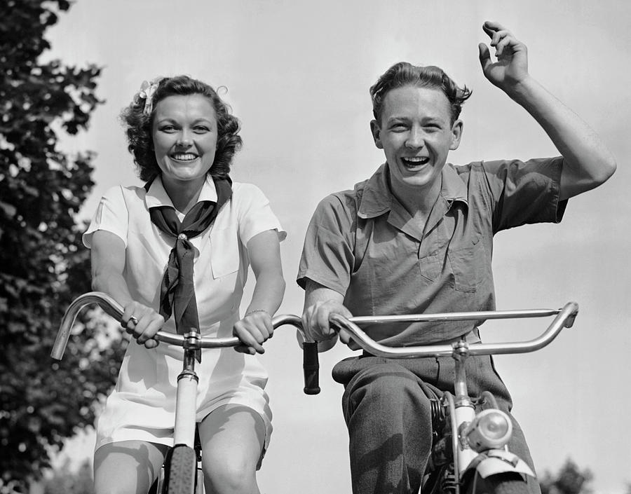 Young Couple Riding Bicycles Photograph by George Marks