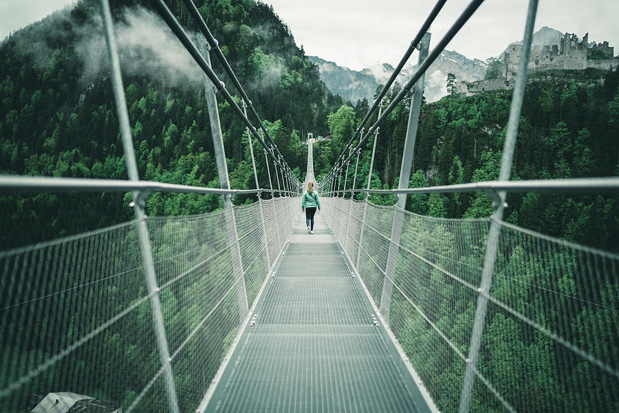 Young Female Hiking Over Suspension Rope Bridge In Alpine Environment ...