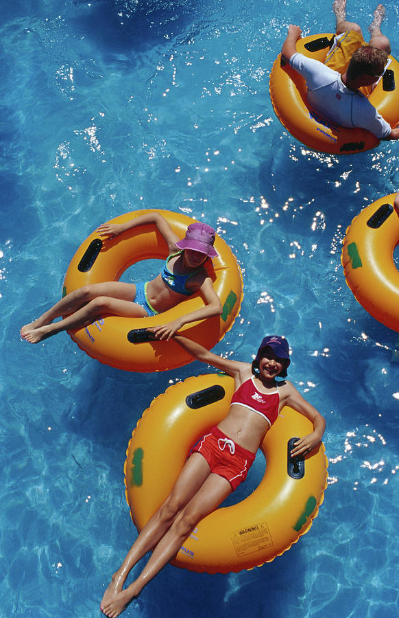 Young Girls Floating In Rubber Rings In Photograph by Richard  Ianson