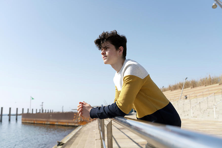 Young Male Leaning On Railing While Looking Pensive Away Photograph By Cavan Images Pixels 