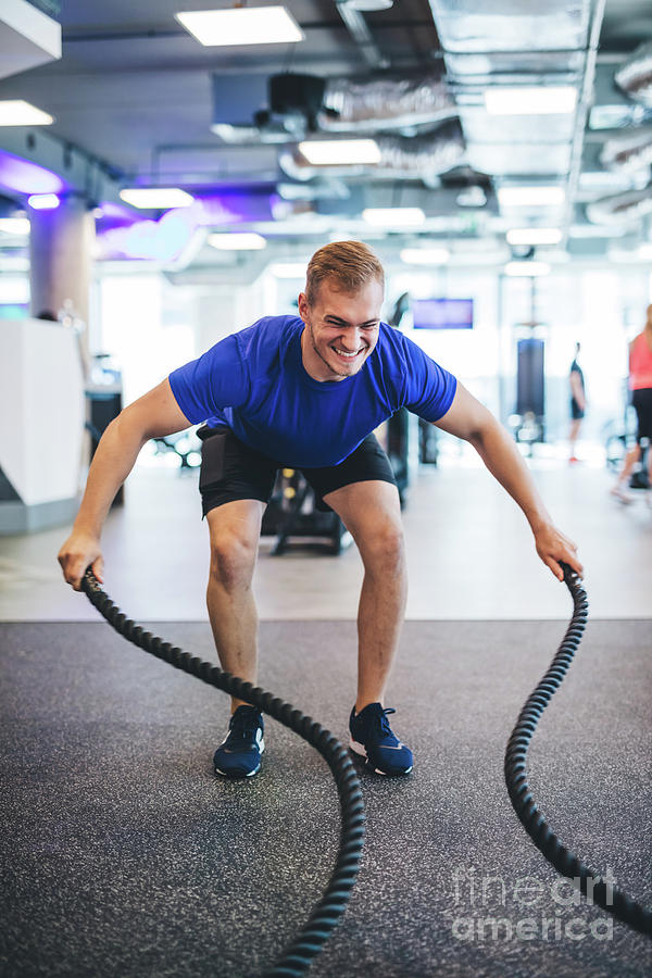 Young man exercising with ropes at the gym. Photograph by Michal Bednarek