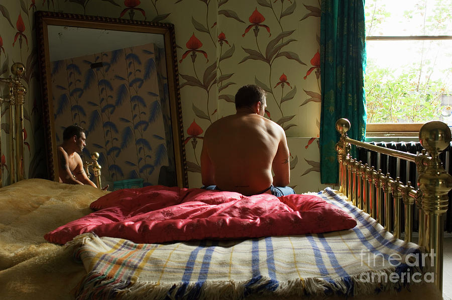 Young Man Sitting At Edge Of Bed Photograph by Tara Moore