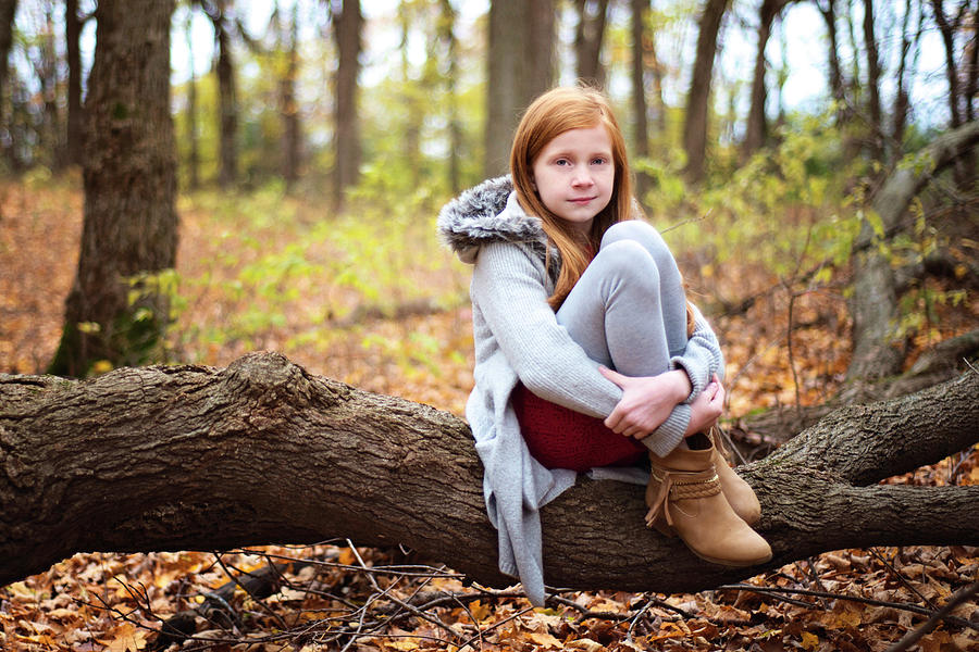 Young Red Haired Girl Sitting On A Log Outside In Fall Photograph by ...