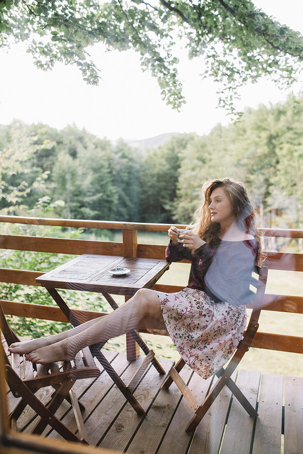 Young Redhaid Woman Drinking Coffee On Tree House Balcony Photograph By Cavan Images Fine Art 