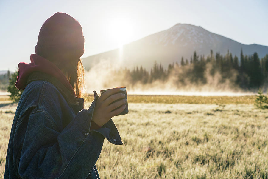 Coffee Photograph - Young Woman Holding Coffee At Sunrise Looking At Foggy Mountain by Cavan Images