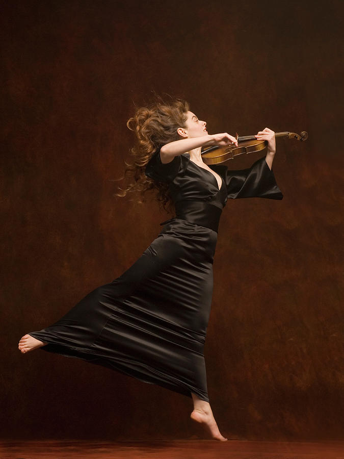 Young Woman Playing Violin And Jumping Photograph by Pm Images