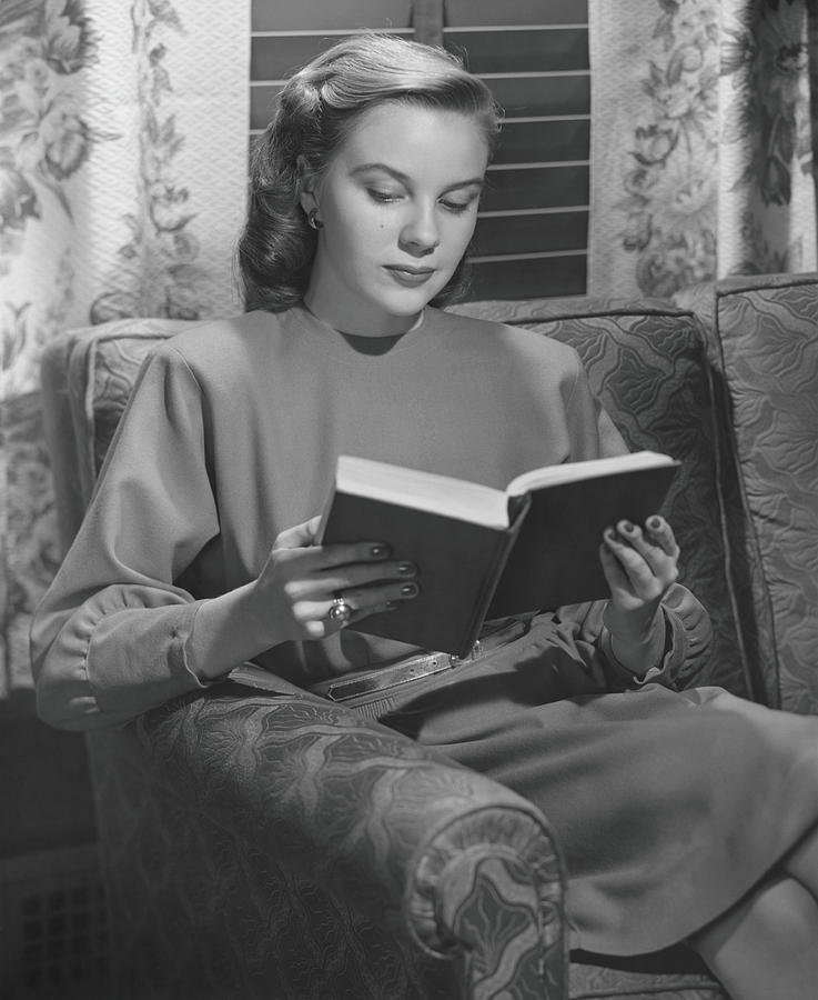 Young Woman Sitting On Sofa, Reading Photograph by George Marks