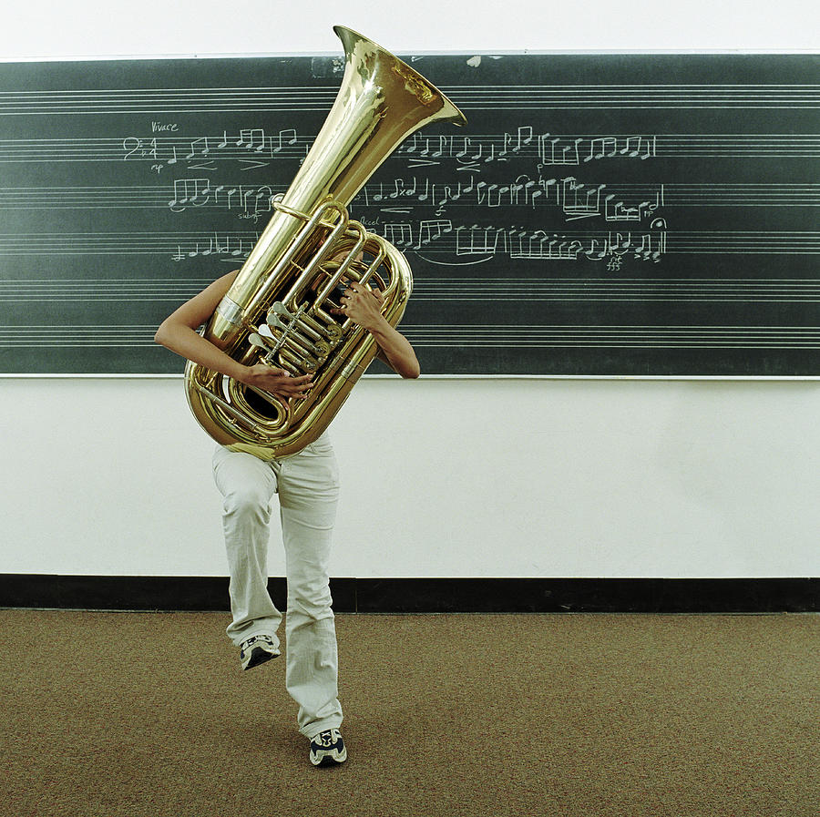 Young Woman Struggling To Hold Tuba In Photograph by Jonathan Kirn