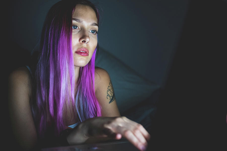 Cool Digital Art - Young Woman With Long Pink Hair Looking At A Laptop, Face Illuminated By The Screen Glow. by Eugenio Marongiu