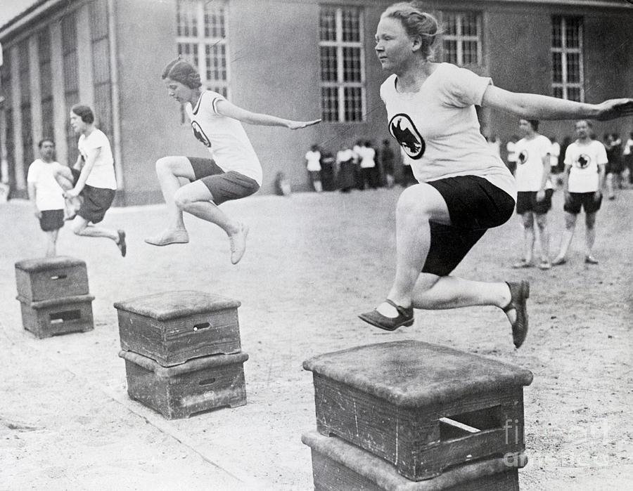 Young Women Hurdling Over Low Obstacles Photograph by Bettmann