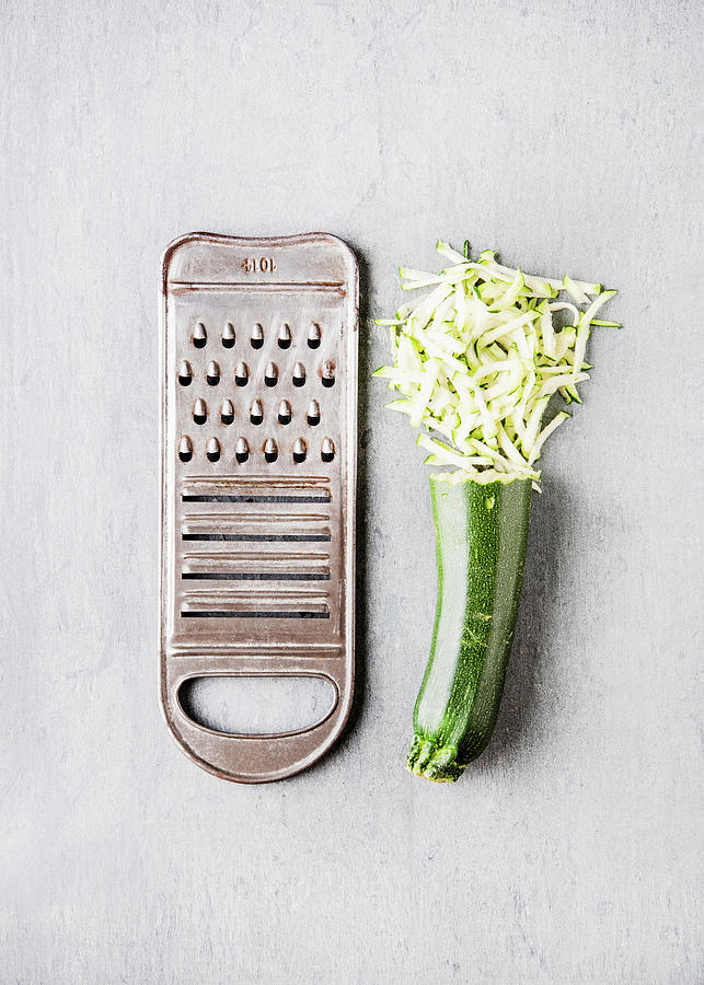 Zucchini, Half Grated, Next To A Vegetable Grater Photograph by Sylvia Meyborg