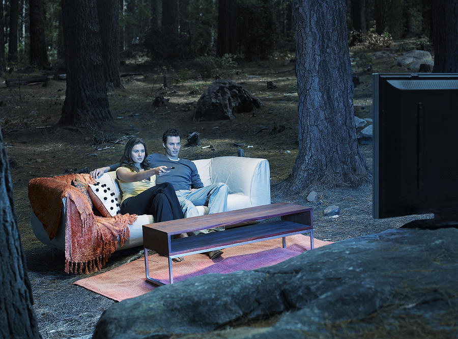 A couple watching television outdoors in the woods #1 Photograph by OJO Images