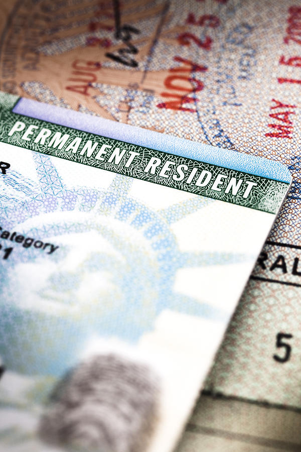 A Green Card lying on an open passport, close-up, full frame #1 Photograph by Epoxydude