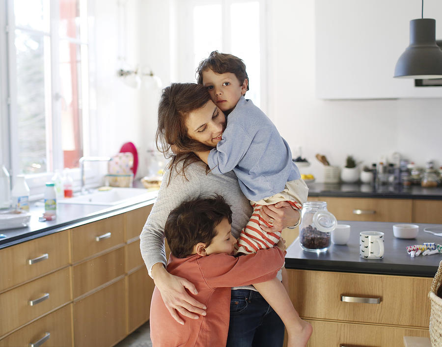 A mom hugging her sons in the kitchen #1 Photograph by Catherine Delahaye