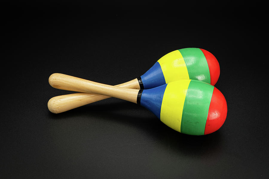 A pair of colorful maracas lying on a black underground Photograph by ...