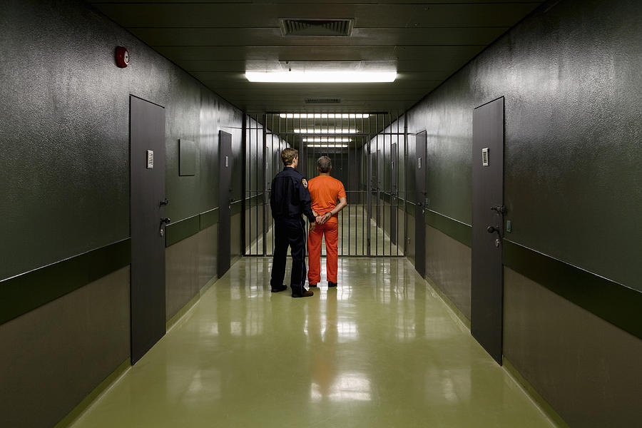 A prison guard leading a prisoner along a corridor #1 Photograph by Halfdark