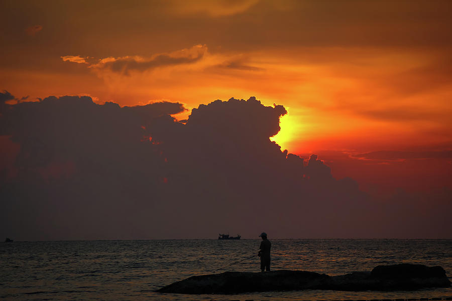 A Silhouette Of Fishermen Standing On Rocks At Sunset At Ba Keo Beach Photograph
