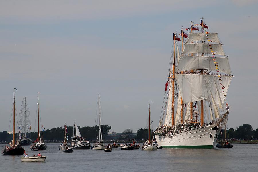 A tall ship escorted by smaller ships on its way to Amsterdam #1 Photograph by Frans Sellies