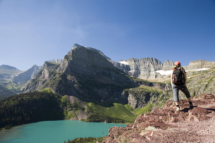 A woman in her early thirties hikes along the Grinnell Glacier trail in Glacier National Park, Montana. #1 Photograph by Dan Shugar