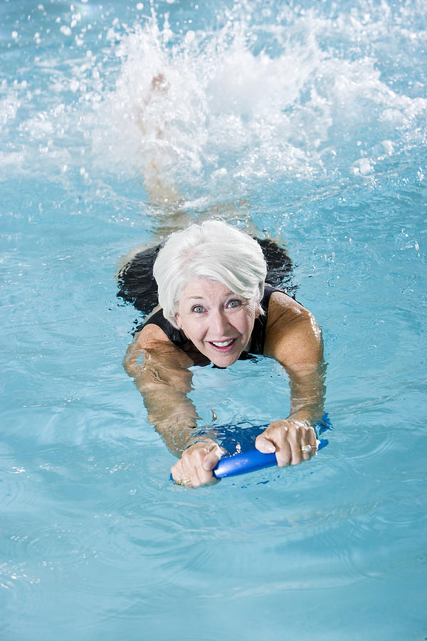 Active senior woman exercising in swimming pool #1 Photograph by Kali9