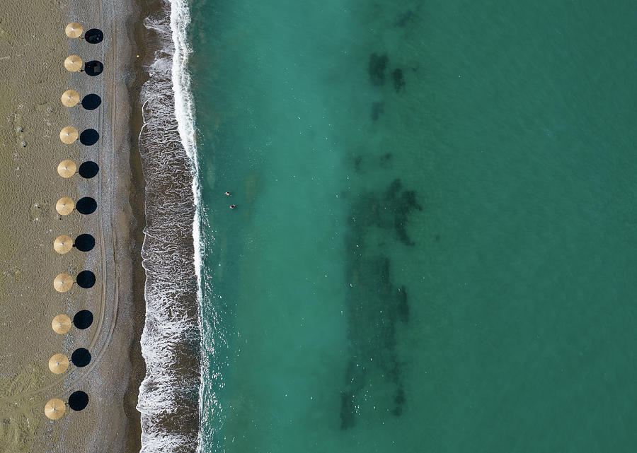 Aerial view from a flying drone of beach umbrellas in a row on an empty beach Photograph by Michalakis Ppalis