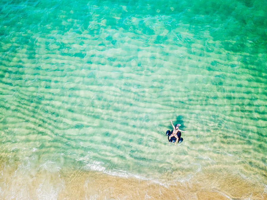 Aerial view of a man floating with a Toucan on the sea #1 Photograph by Noelia Ramon - TellingLife