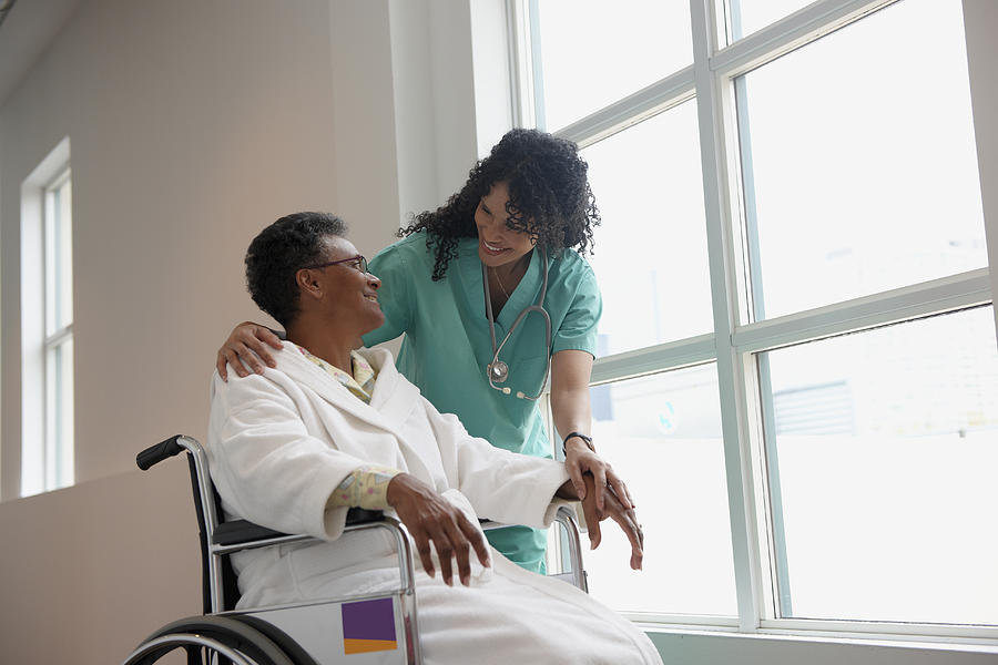 African American nurse checking on patient in wheel chair #1 Photograph by LWA/Dann Tardif