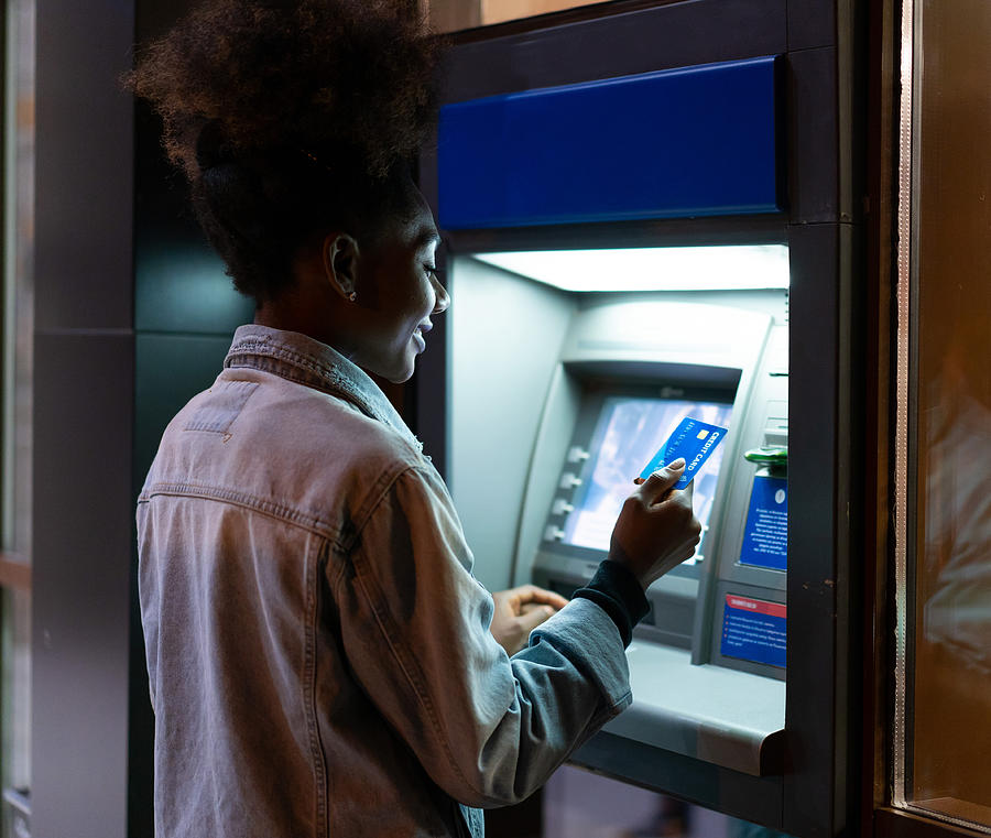 Afro American woman withdrawing money at the ATM #1 Photograph by Valentinrussanov