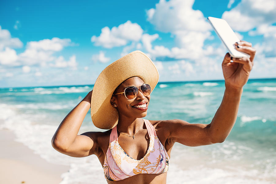 Afro-Caribbean woman enjoys summer at the beach in USA #1 Photograph by Drazen_