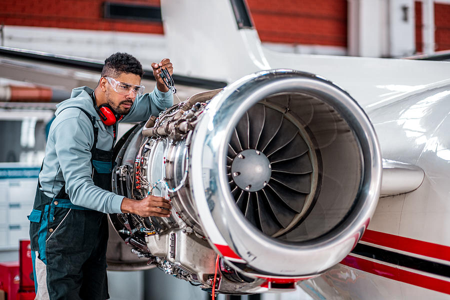 Aircraft Mechanic checking jet engine of the airplane #1 Photograph by Extreme-photographer