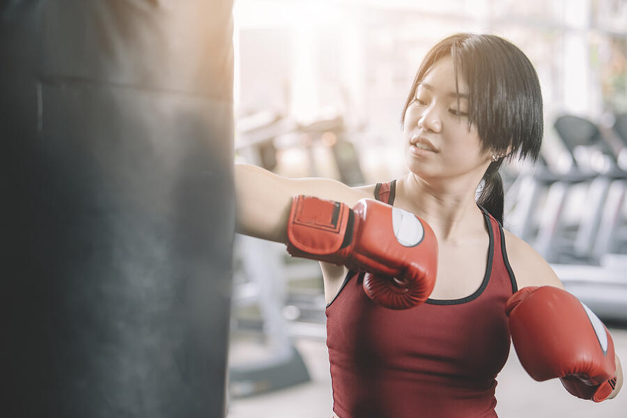 An Asian Chinese Female Teenager Athlete Wearing Boxing Gloves Workout In Gym During Weekend #1 Photograph by Edwin Tan