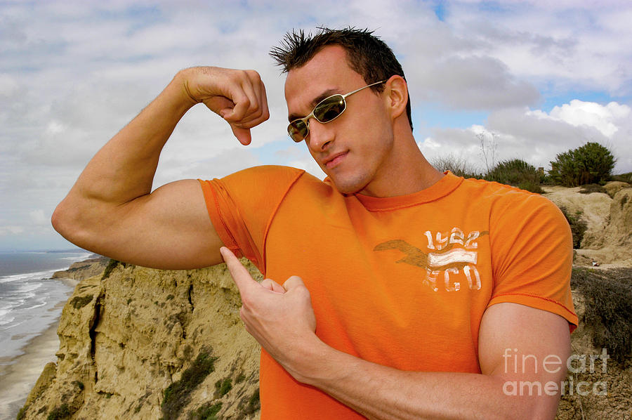 An athletically fit and attractive young man flexes his biceps. #1 Photograph by Gunther Allen