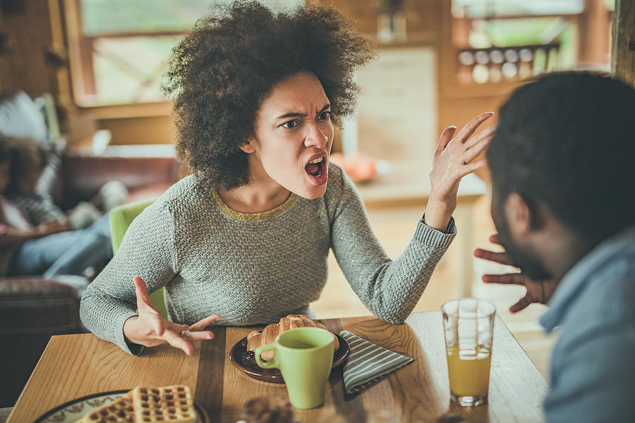 Angry African American woman arguing with her husband at dining table. #1 Photograph by Skynesher