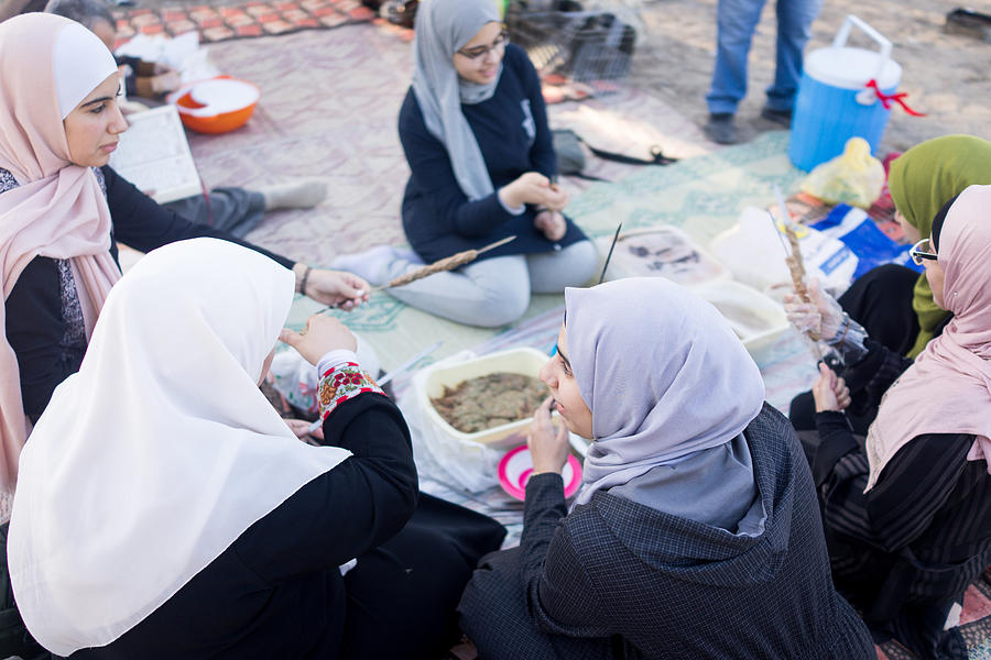 Arab family gathering around food outdoors #1 Photograph by Jasmin Merdan