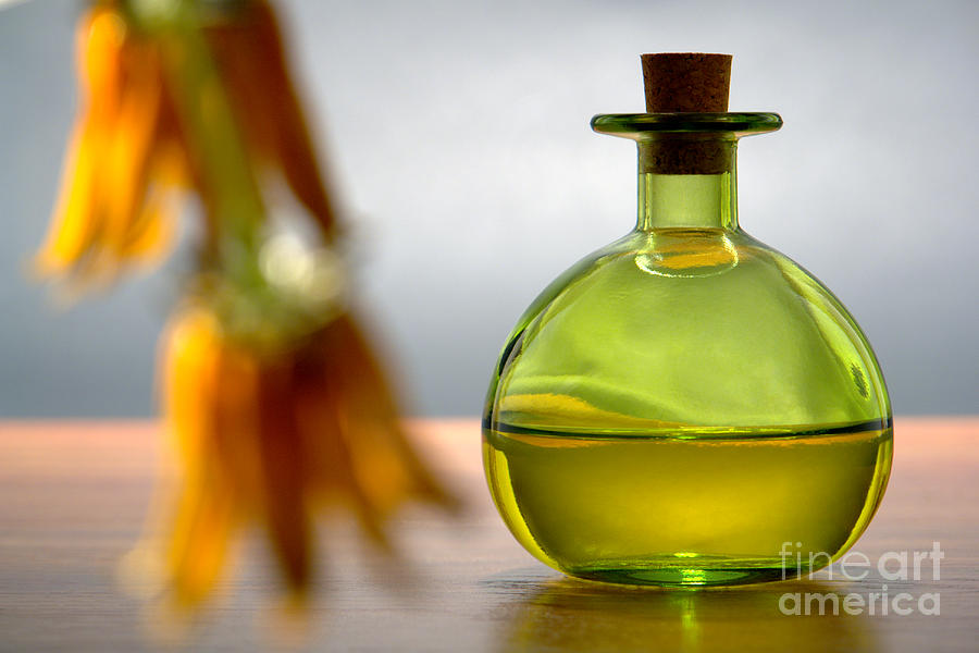Green Aromatherapy Bottle with Flower Foreground Photograph by Olivier Le Queinec