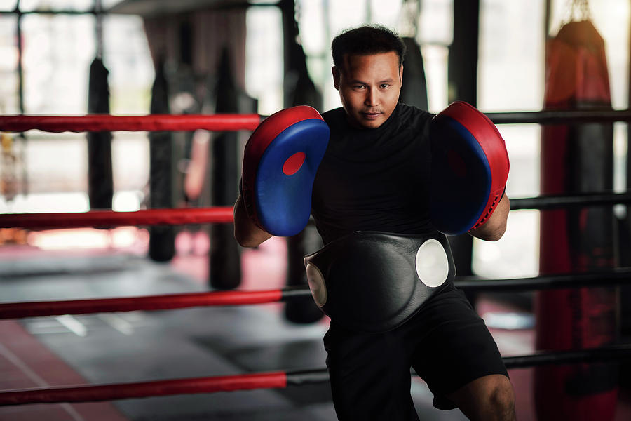 Asian kickboxing trainer in boxing gym Photograph by Anek Suwannaphoom